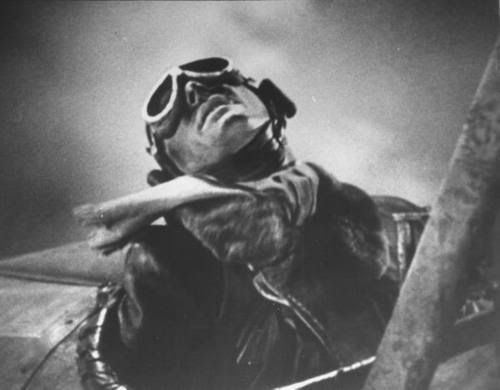 x-plane - Actor Errol Flynn as WWI pilot, dead in open aircraft cockpit during suicide mission, in scene from film “The Dawn Patrol.” (1938)