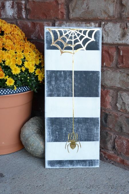 DIY Halloween sign with black and white stripes and gold spider